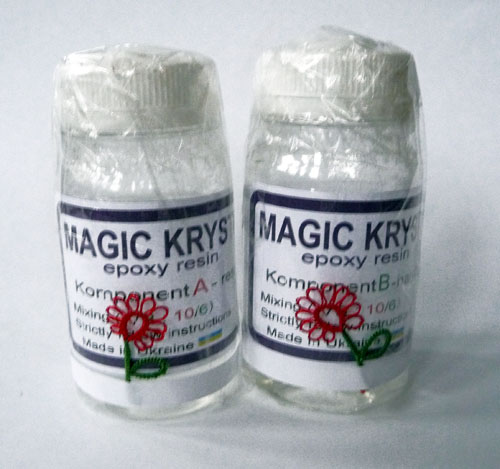 Two 100ml clear bottles of epoxy resin and hardener, each decorated with a small tatting lace flower — materials ready for making resin items, handmade by FairyLacefromElena.