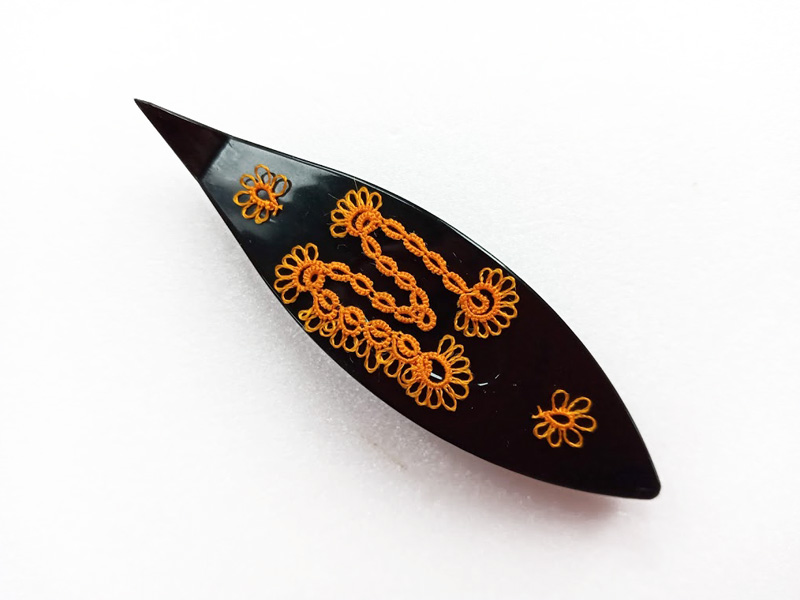 Black tatting shuttle with lace letter M in orange thread by FairyLacefromElena