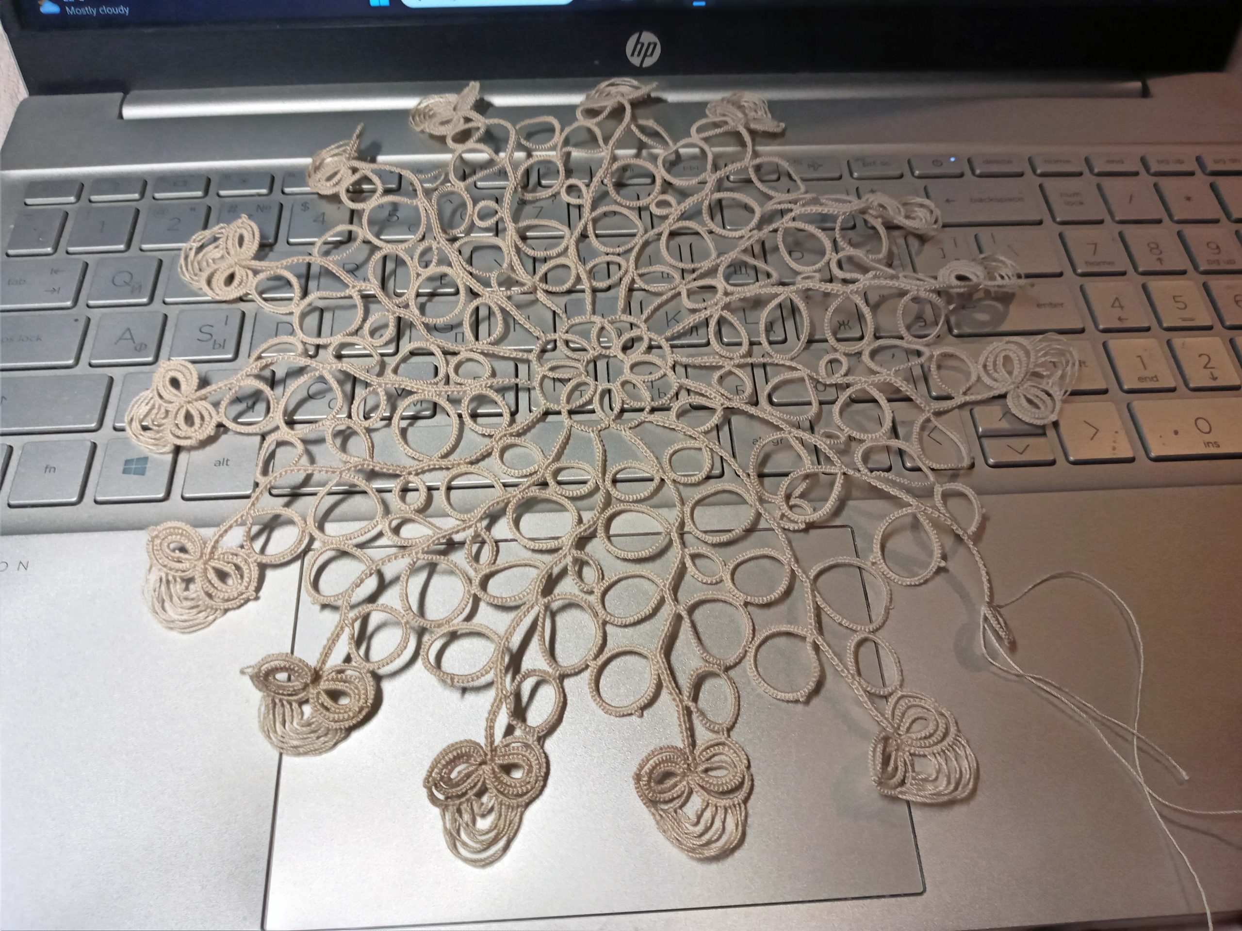 Fragment of a round doily in the tatting technique